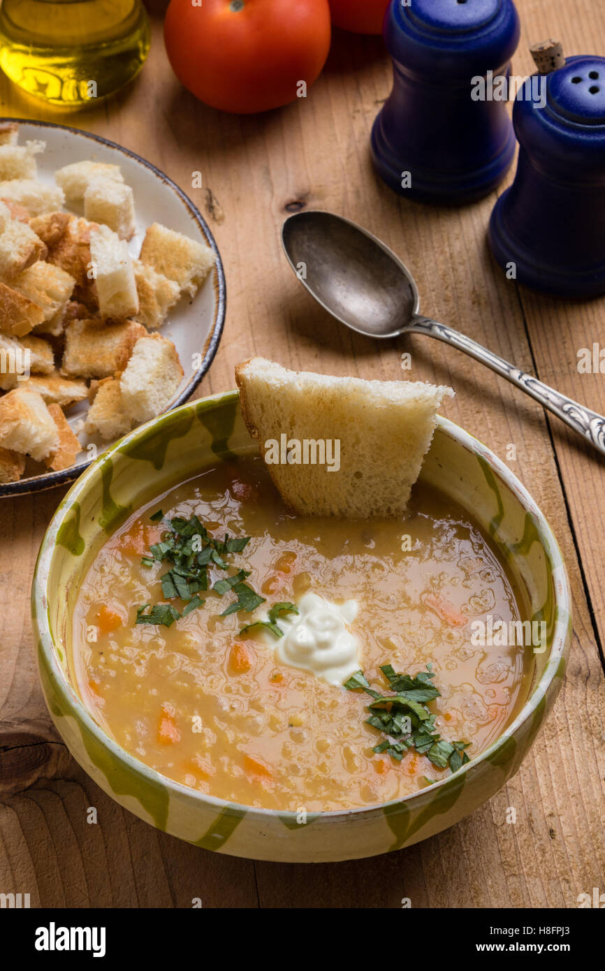 red lentil soup in bowl on rustic table setting Stock Photo