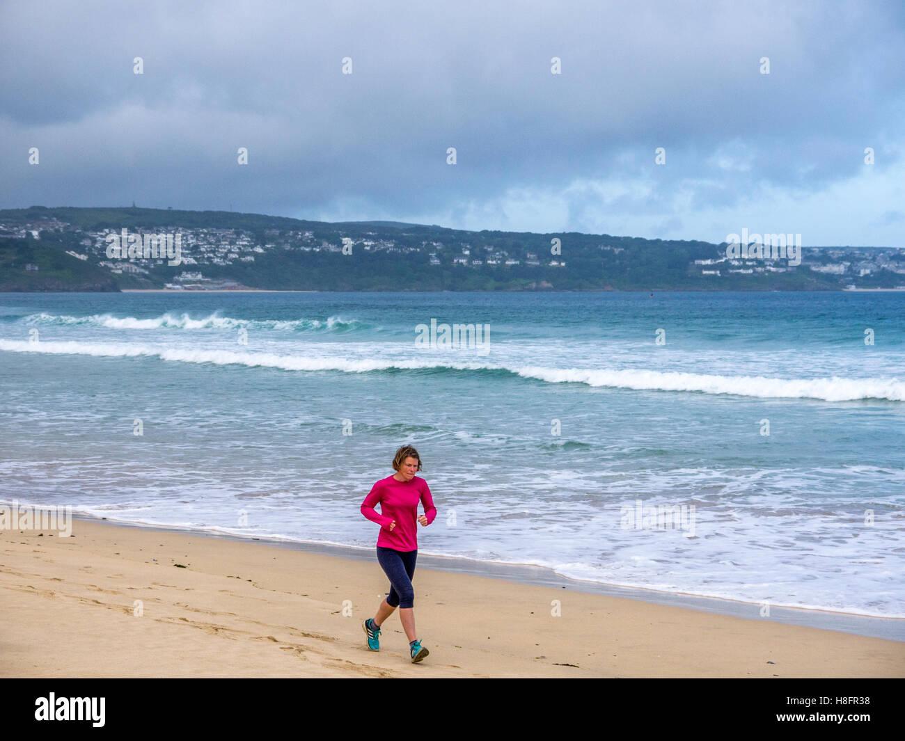 Women jogging on a beach in Cornwall. Stock Photo