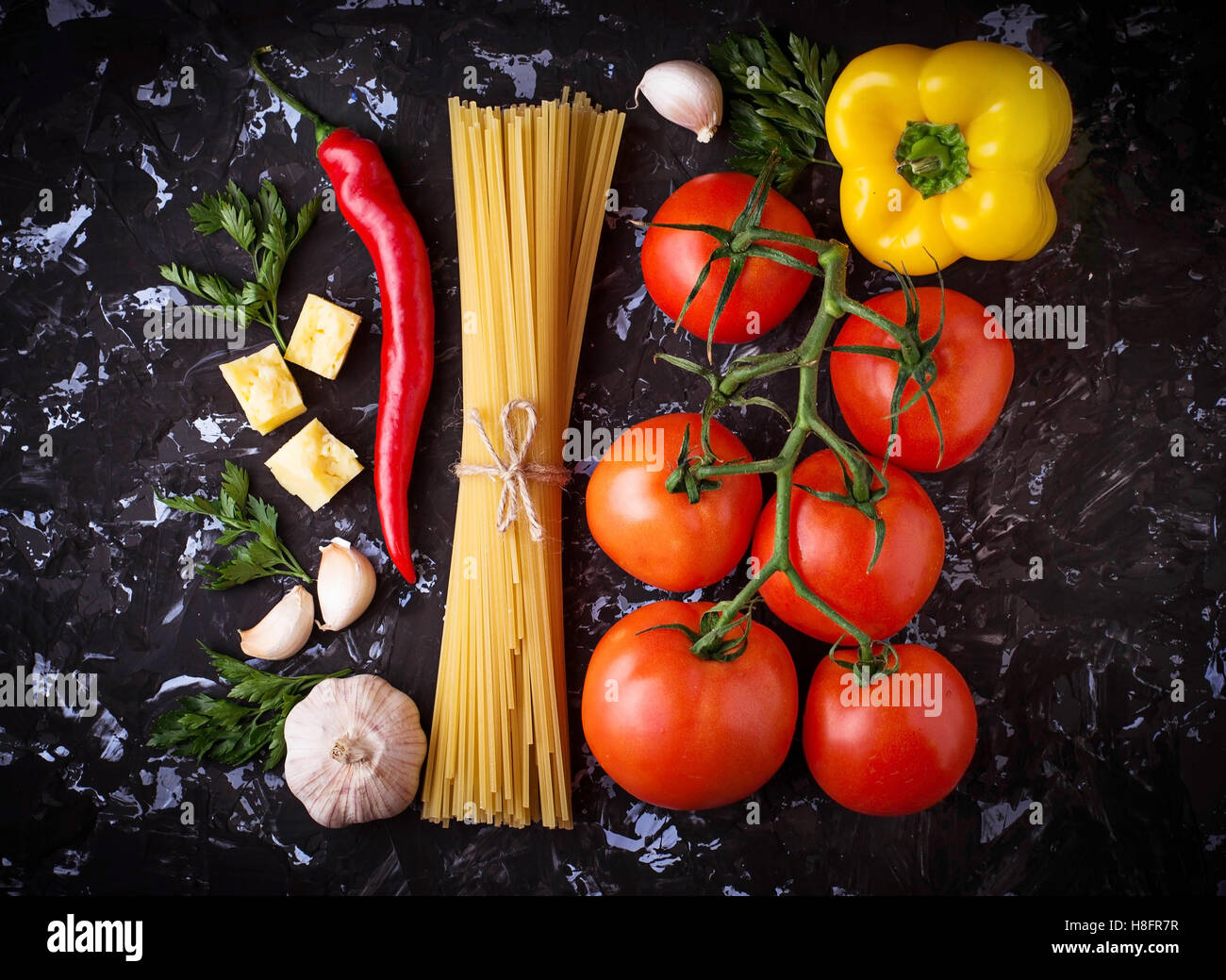 Concept of Italian food. Pasta, tomato, olive oil, pepper, parsley and cheese. Selective focus