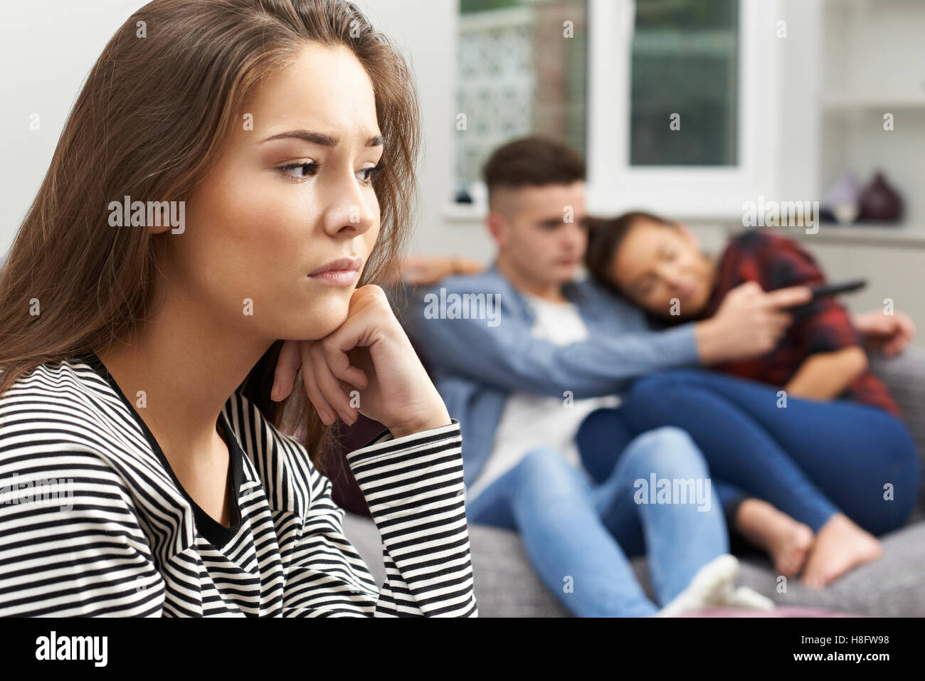 Teenage Girl Jealous Of Young Couple At Home Stock Photo - Alamy