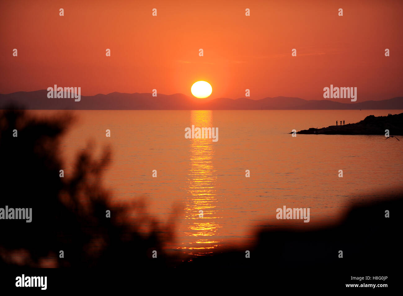 Adriatic sea islands at sunset with people on the shoreline Stock Photo