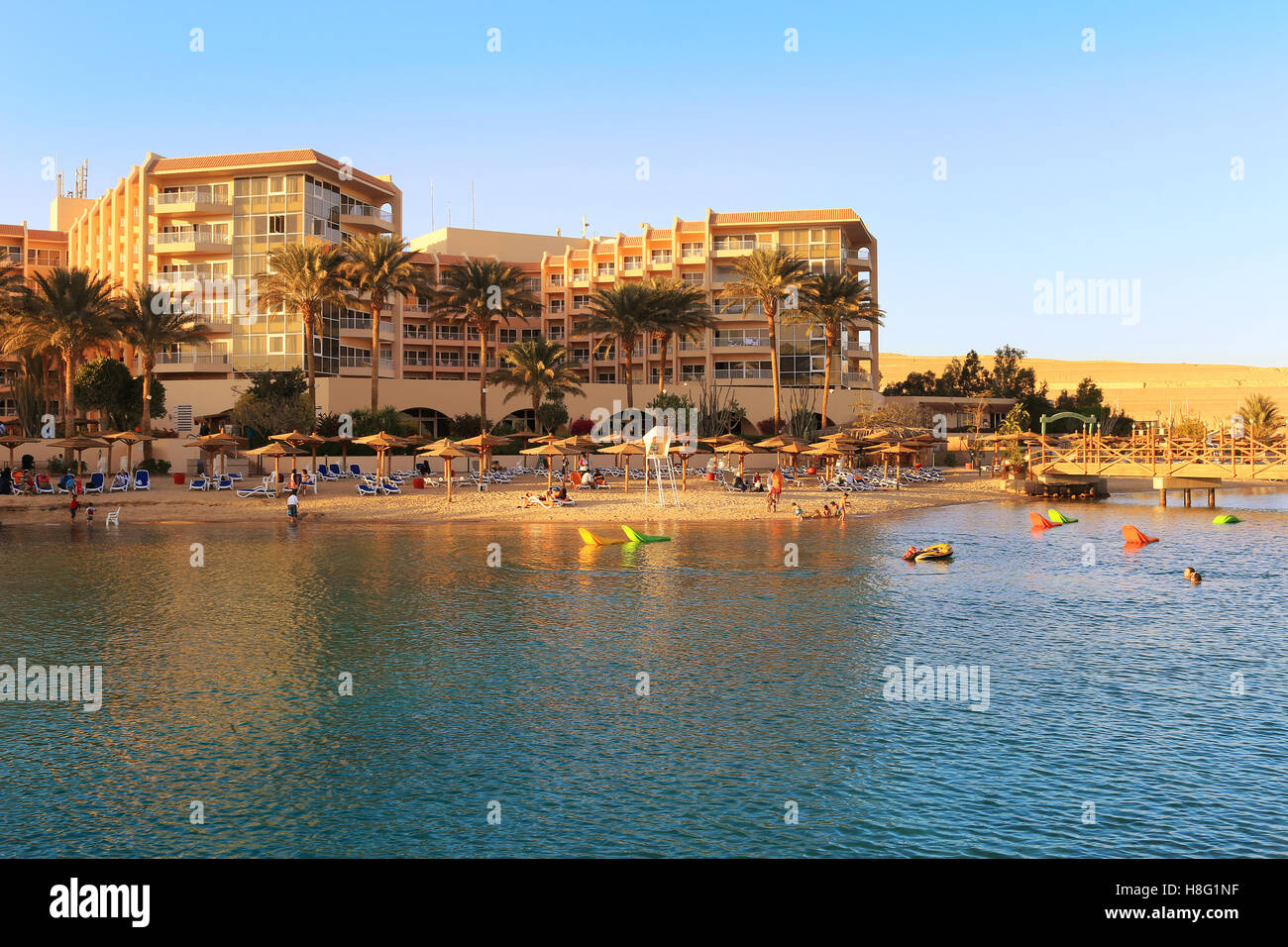 People enjoying the beach area with sun shades and lounging chairs at a resort on the Red Sea in Hurghada, Egypt Stock Photo