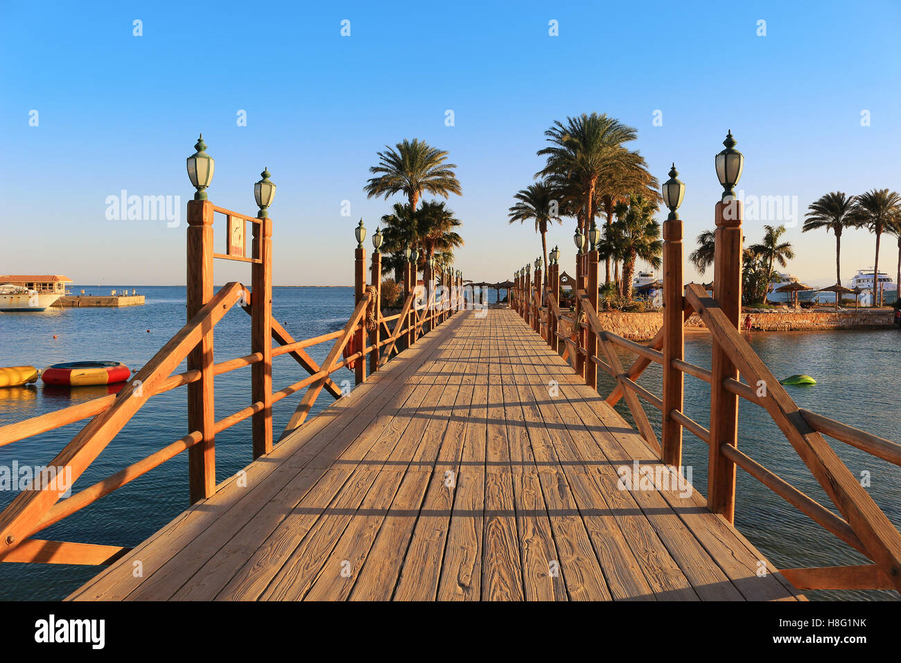 Long wooden boardwalk with lamposts on a sunny day in Hurghada, Egypt Stock Photo