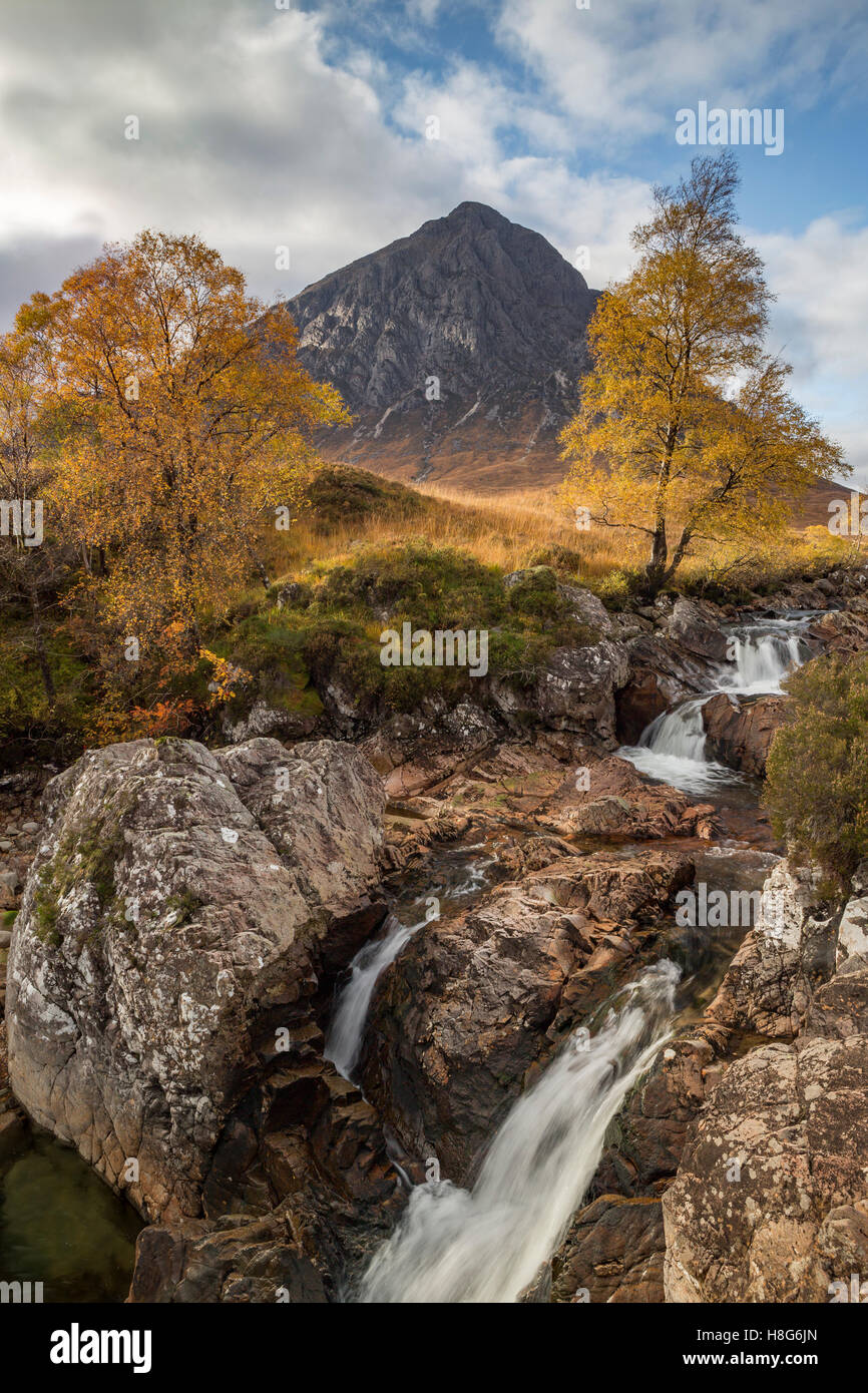 Buachaille Etive Mòr towers over the waterfall along River Coupall, Glen Etive in the Highlands of Scotland. Stock Photo