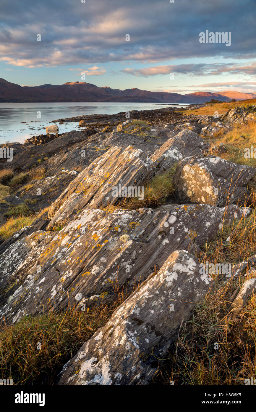 Boulders along Loch Linnhe are lit up by the setting sun. Stock Photo