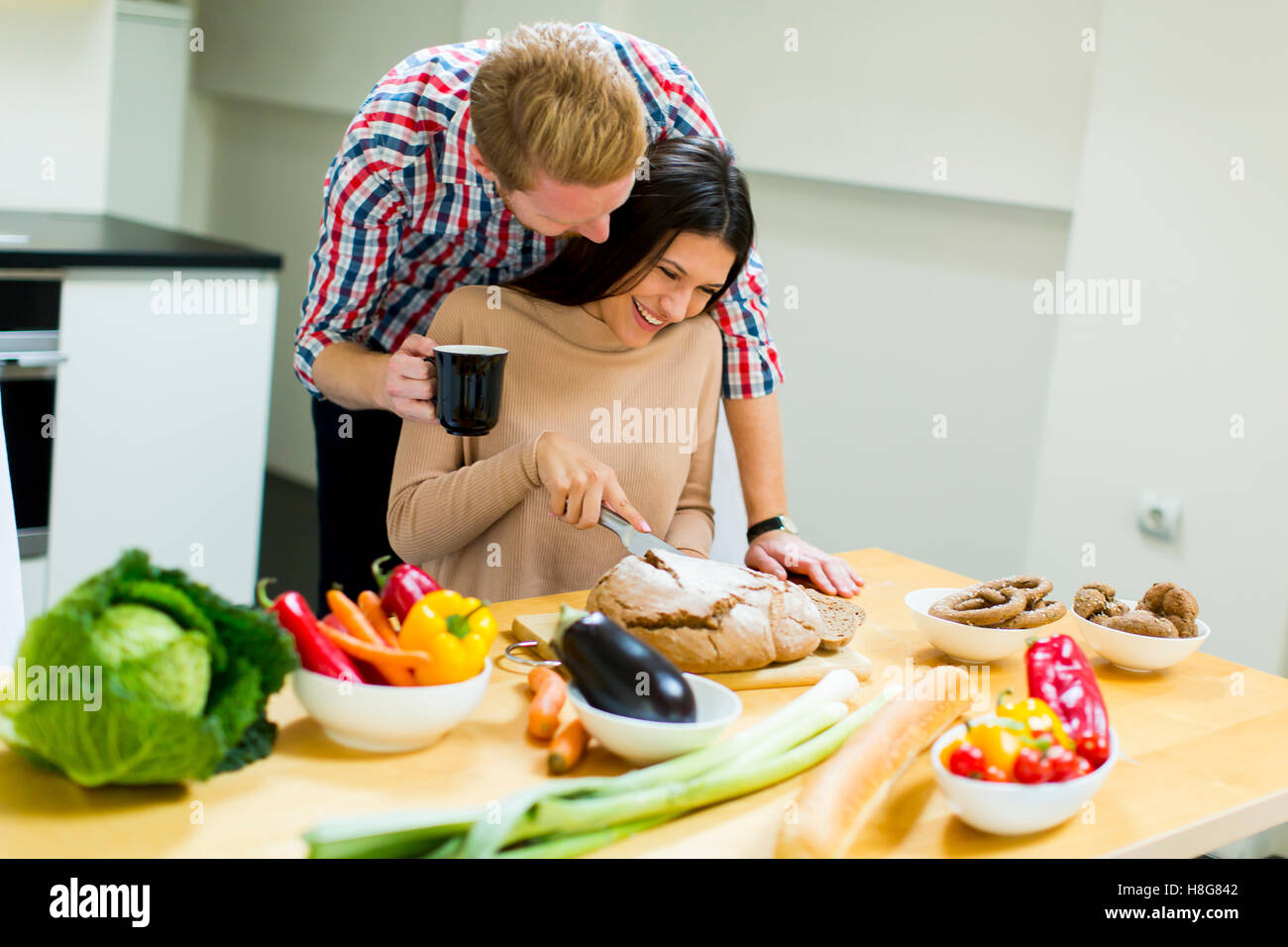 Happy young couple preparing food in the kitchen Stock Photo