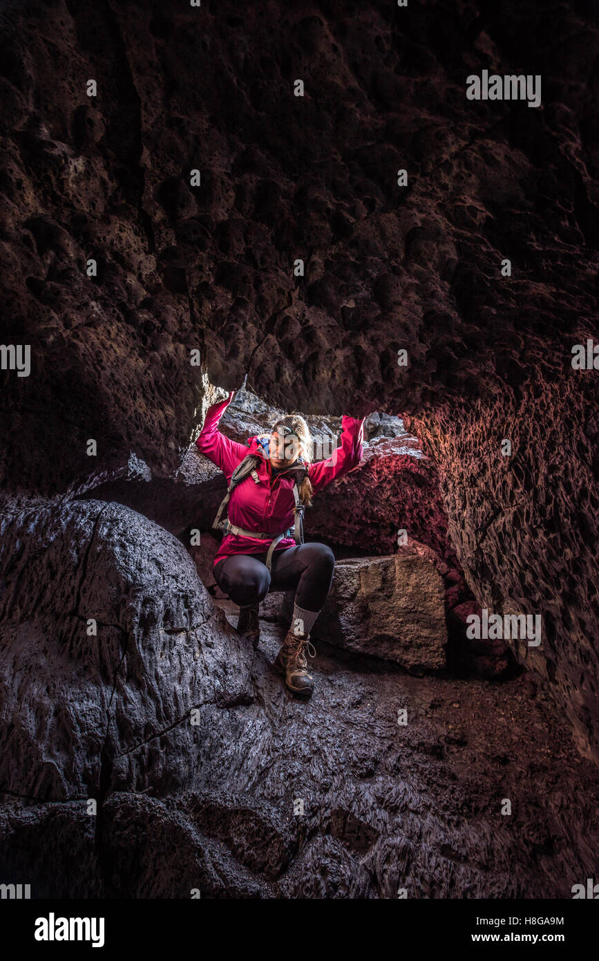 Girl entering Volcanic Cave Indian Tunnel Crater of the Moon Idaho Stock Photo