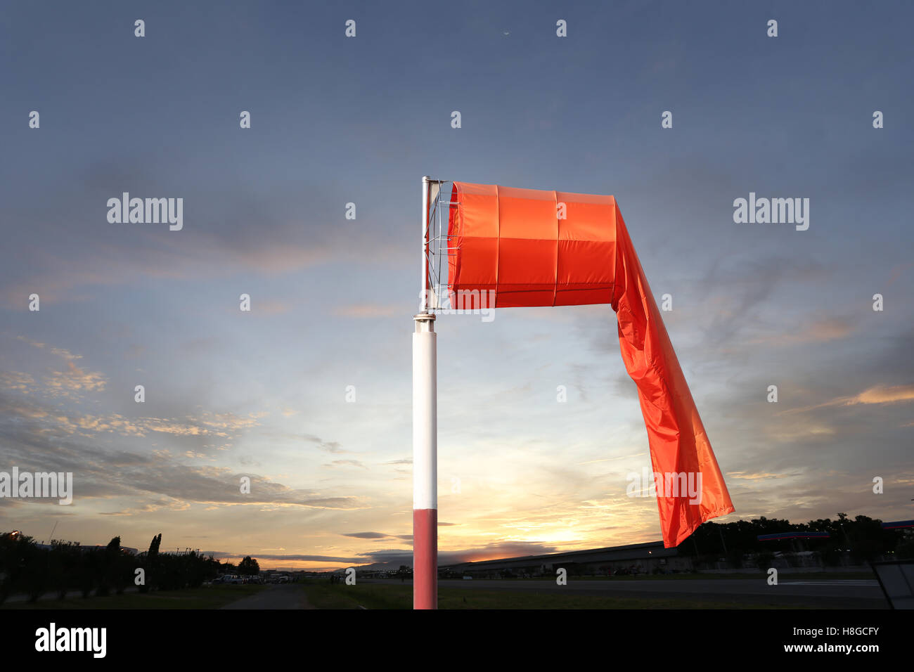 Wind sock of equipment check the wind blow direction in sunrise background. Stock Photo