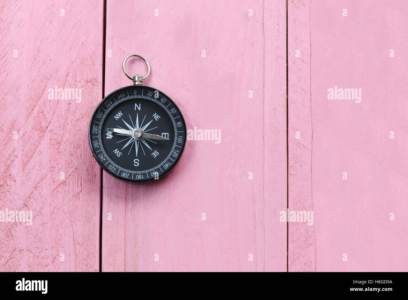 Compass on the pink wooden floor,concept of traveling and trekking. Stock Photo