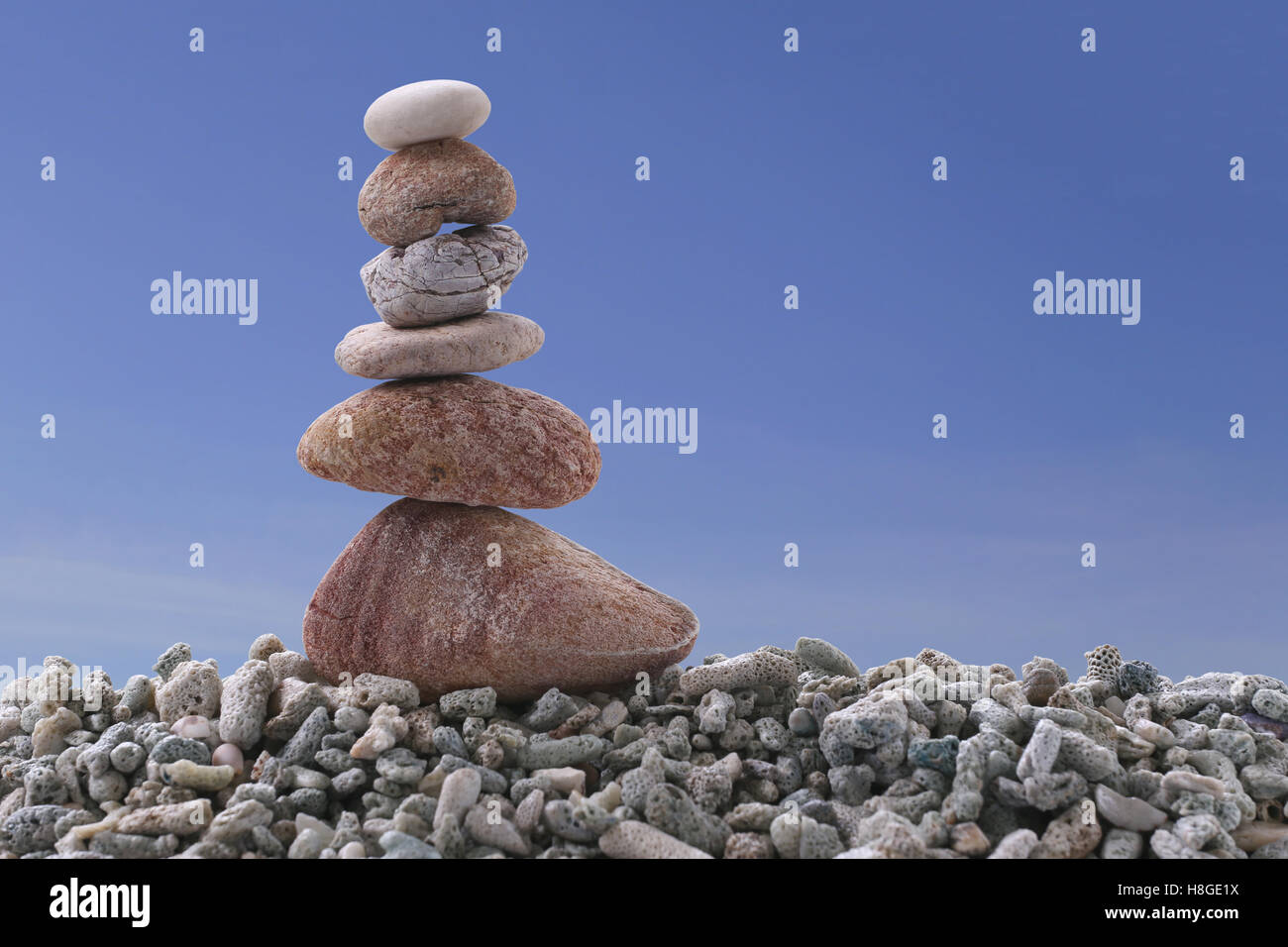 Balance stone on pile rock with blue sky background for concept of Zen and calm. Stock Photo