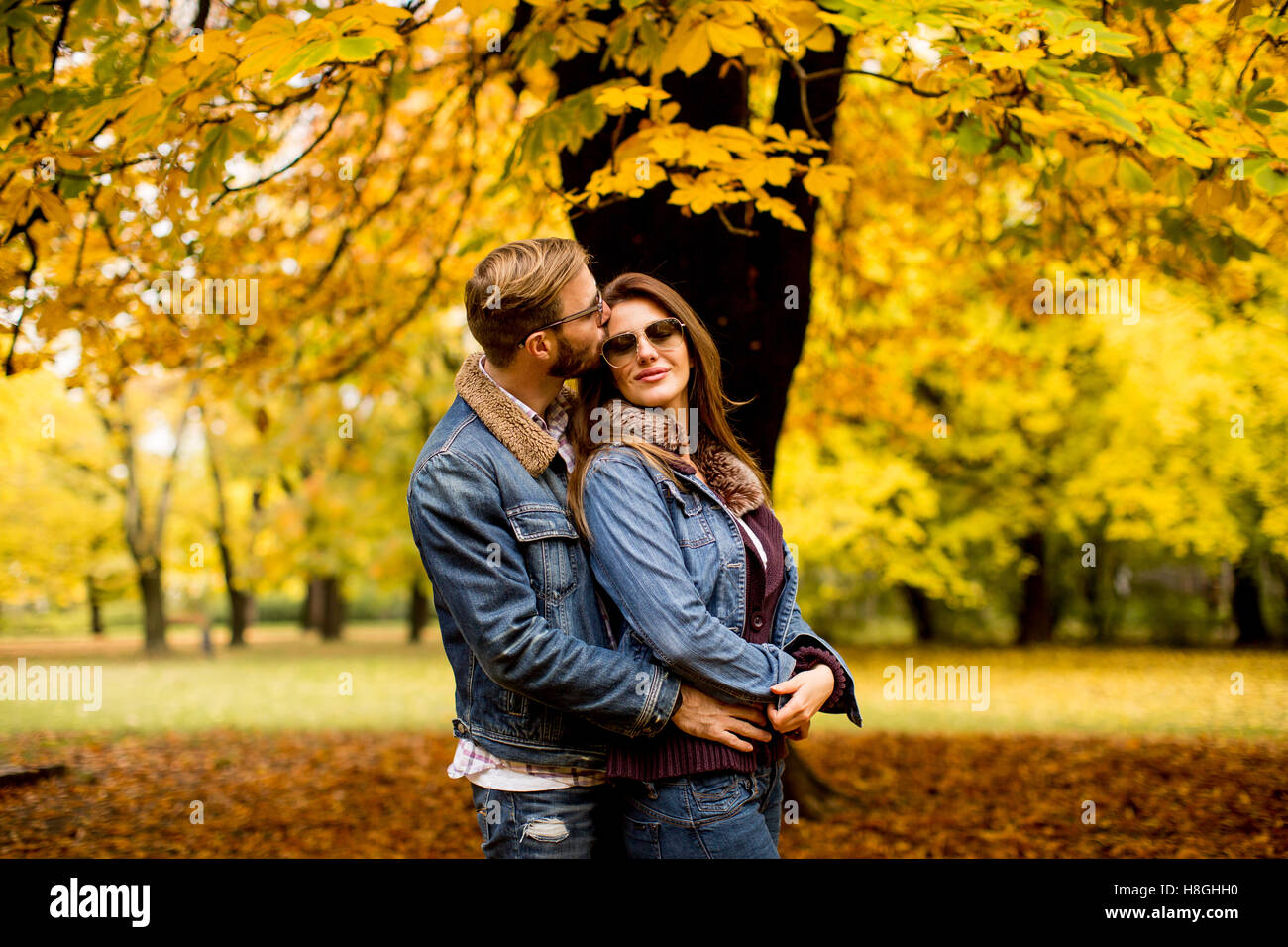 Young couple posing in the autumn park Stock Photo - Alamy