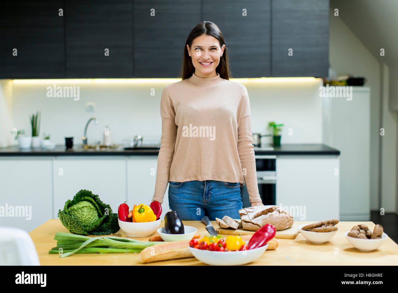 Pretty young woman preparing food in the modern kitchen Stock Photo