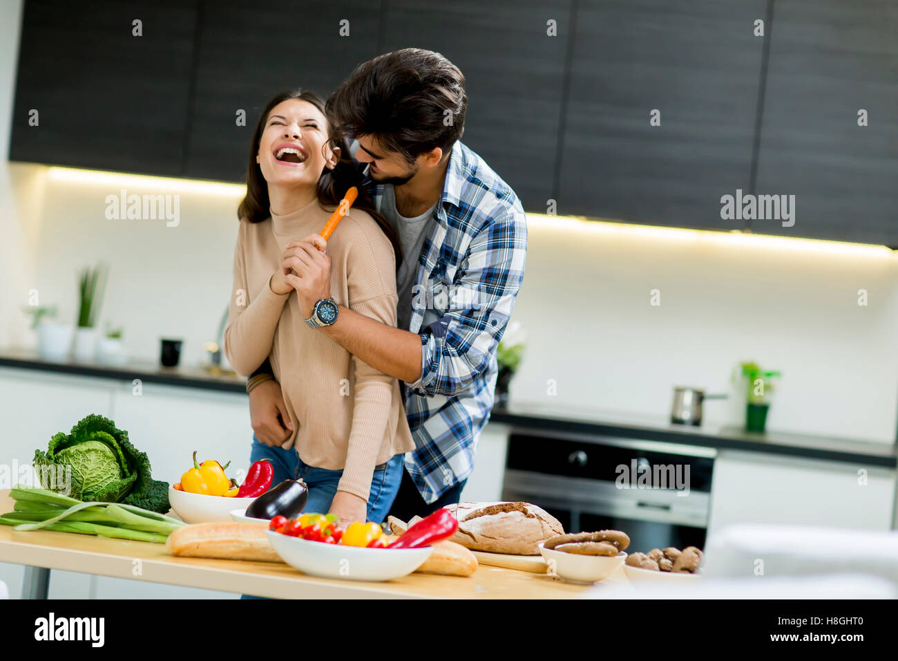 Young couple having fun while preparing food in the kitchen Stock Photo