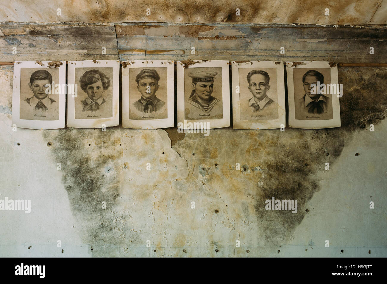 Paper Portraits Of Young Pioneers, Heroes Of WW2 War On Cracked Wall Of Classroom In Abandoned School After Chernobyl Nuclear Di Stock Photo