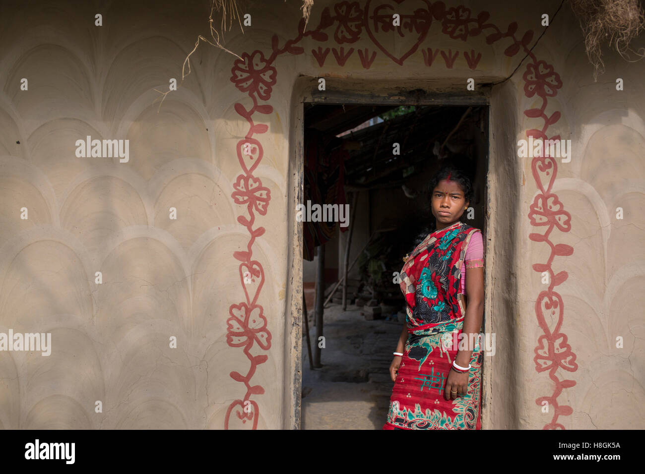 North Bengal, Bangladesh. 11th November, 2016. A santal women inside her house in North Bengal in Bangladesh, on November 10, 2016. lifestyle and view of houses of a rural village in Bangladesh. These houses are made by mud and  the walls are beautifully painted using natural colours and the interiors.Santal tribe and hindu people are living these houses.The village paintings are considered auspicious symbols related to fertility and fecundity being painted on the walls. Credit:  zakir hossain chowdhury zakir/Alamy Live News Stock Photo