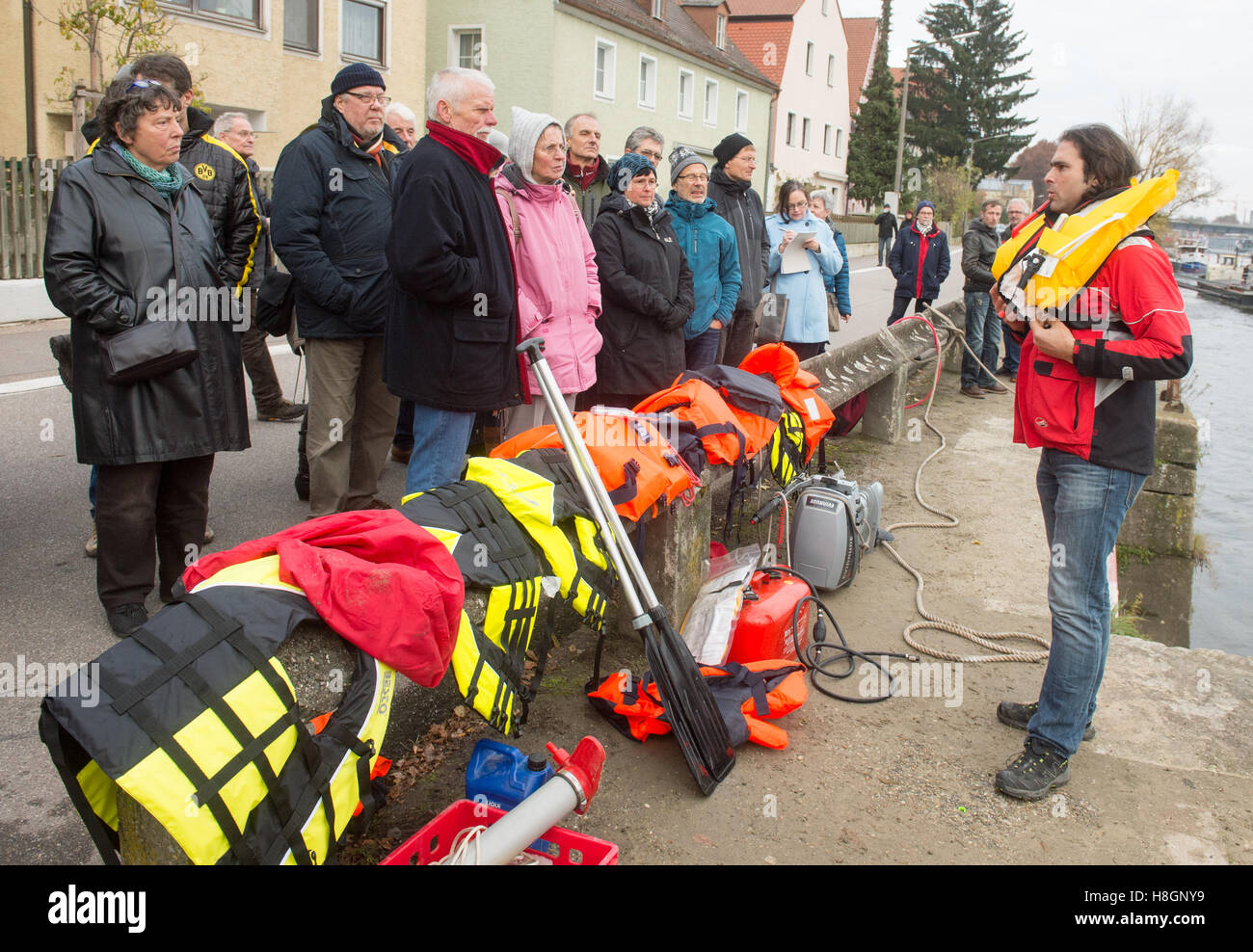 Regensburg, Germany. 12th Nov, 2016. The initatior of the refugee initiative 'Sea Eye, ' Michael Buschheuer (R), explains how to use a life vest during a rescue drill on the Danube river in Regensburg, Germany, 12 November 2016. The organization reports that the German rescue ship 'Sea-Eye' saved more than 5,500 refugees from the Mediterranean Sea this year. Photo: ARMIN WEIGEL/dpa/Alamy Live News Stock Photo