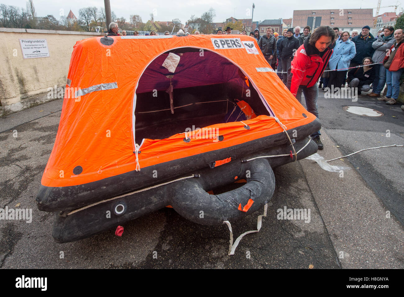 Regensburg, Germany. 12th Nov, 2016. The initatior of the refugee initiative 'Sea Eye, ' Michael Buschheuer (R), explains how to use a life raft during a rescue drill on the Danube river in Regensburg, Germany, 12 November 2016. The organization reports that the German rescue ship 'Sea-Eye' saved more than 5,500 refugees from the Mediterranean Sea this year. Photo: ARMIN WEIGEL/dpa/Alamy Live News Stock Photo