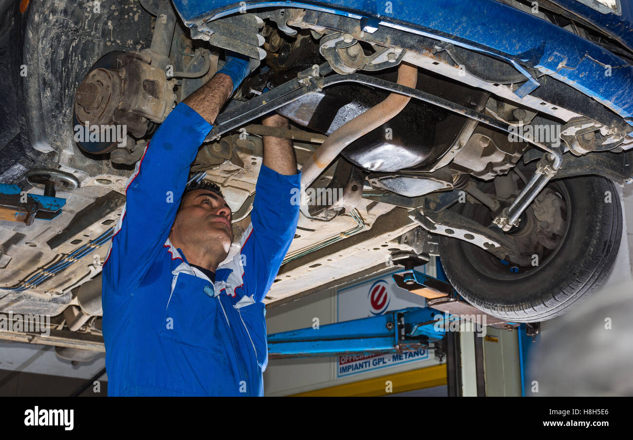 Car mechanic fixing an engine in his garage. copy space Stock Photo - Alamy