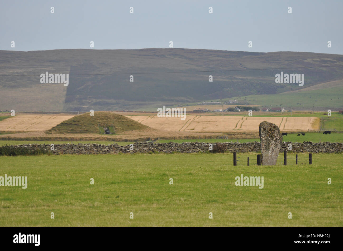 Maeshowe, a Neolithic tomb on Orkney Mainland, with a standing stone Stock Photo
