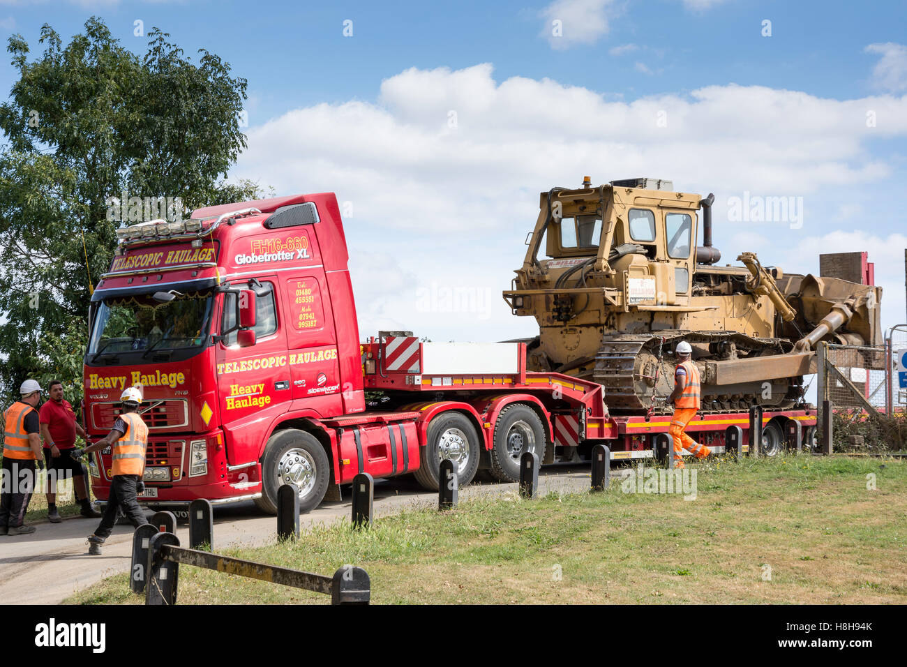 Grader being transported on haulage truck, Waterside Drive, Walton-on-Thames, Surrey, England, United Kingdom Stock Photo