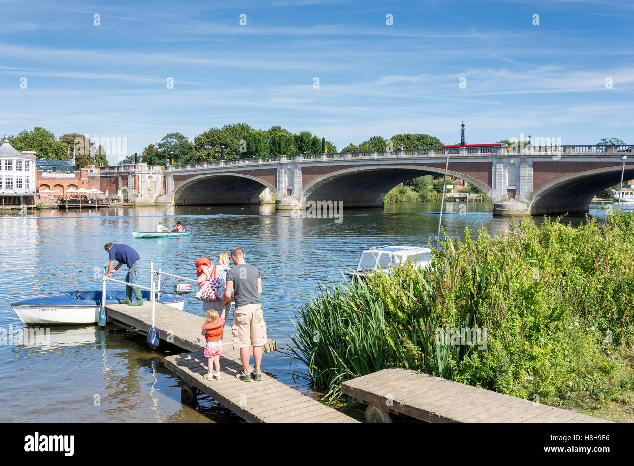 Family hiring boat by Hampton Court Bridge over River Thames, East Molesey, Surrey, England, United Kingdom Stock Photo