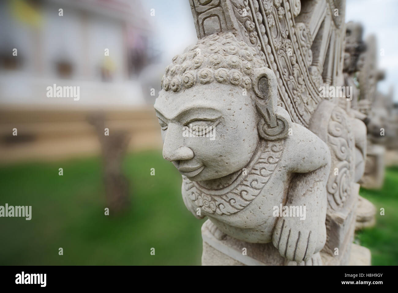 Stone statue imitating art of Asian ancient located in the outdoor area of temple. Stock Photo