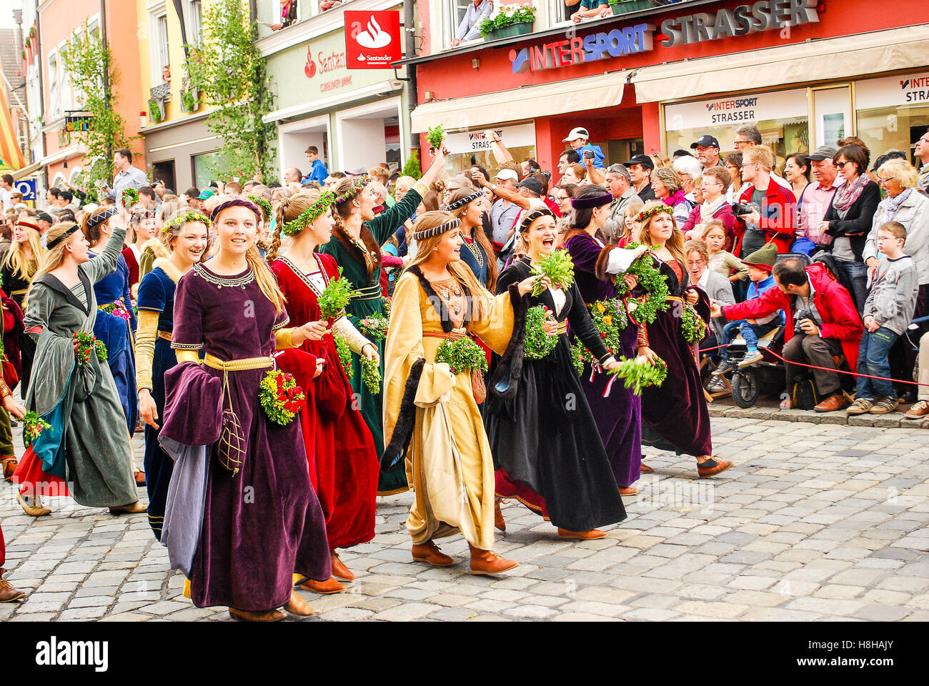 Girls in medieval costumes wave to the crowds at the start of the parade during the Landshuter Hochzeit pageant Stock Photo