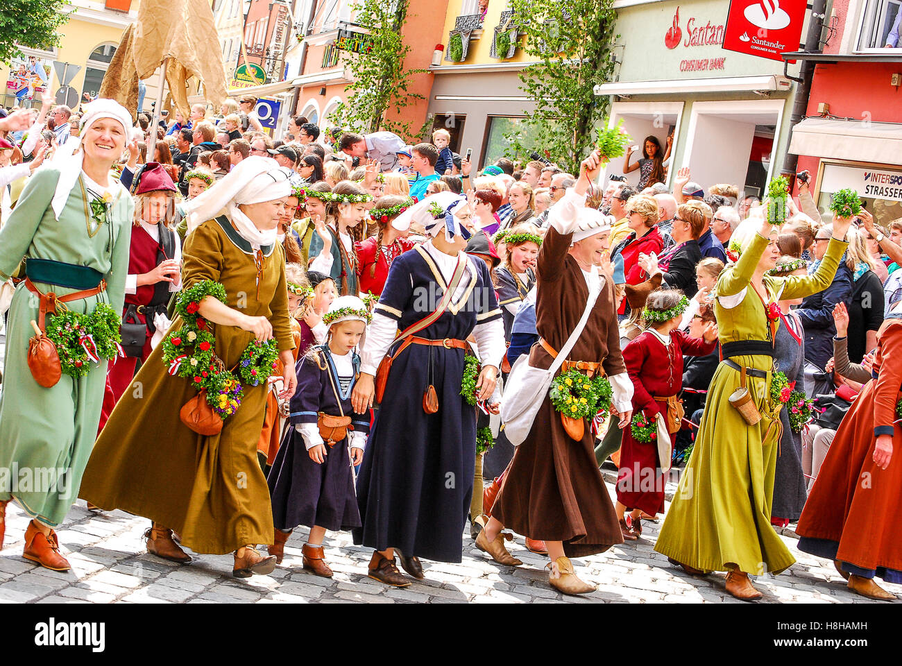 People in medieval costumes wave to the crowds at the start of the parade during the Landshuter Hochzeit medieval pageant Stock Photo
