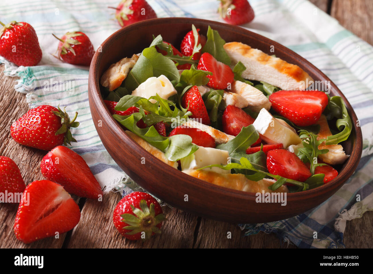 Fresh salad with strawberry, chicken, brie and arugula close-up on the table. horizontal Stock Photo