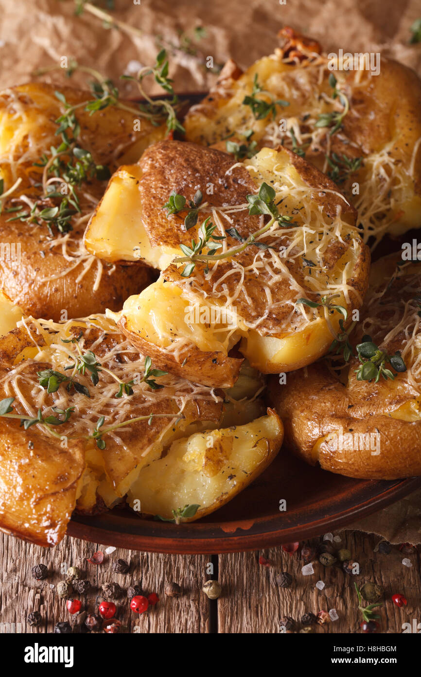 Australian young crash hot potatoes with thyme and cheese macro. Vertical Stock Photo