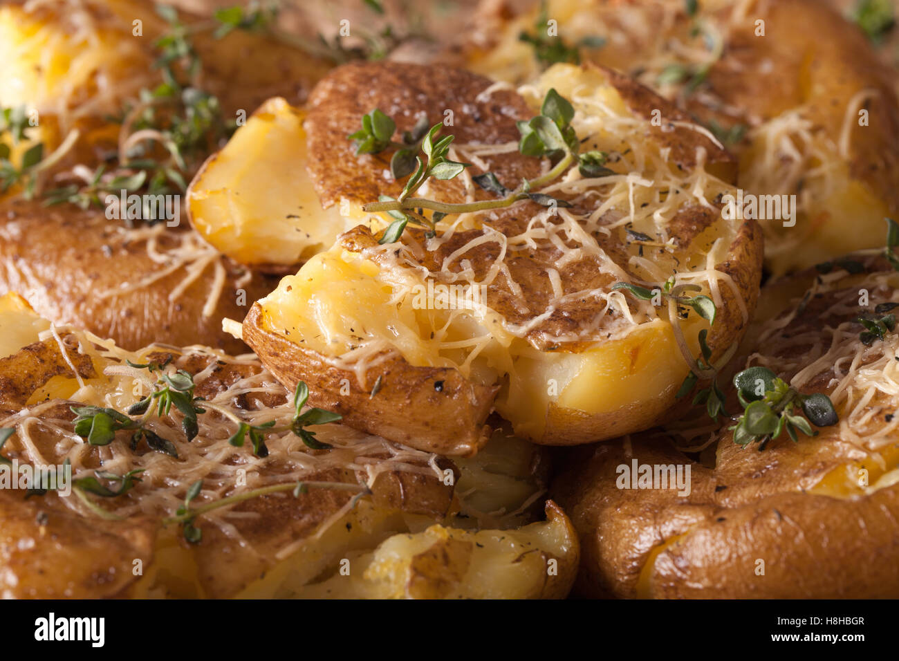 Australian young crash hot potatoes with thyme and cheese macro. horizontal Stock Photo