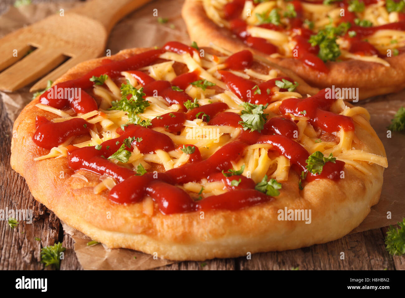 Hungarian deep fried fast food langos with cheese and ketchup on the
