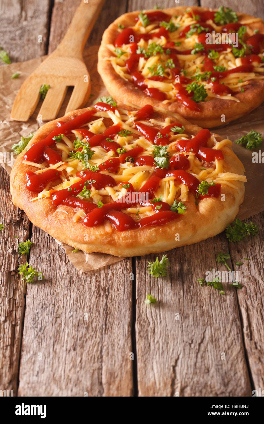 Homemade Hungarian langos with cheese and ketchup on the table close-up. vertical Stock Photo