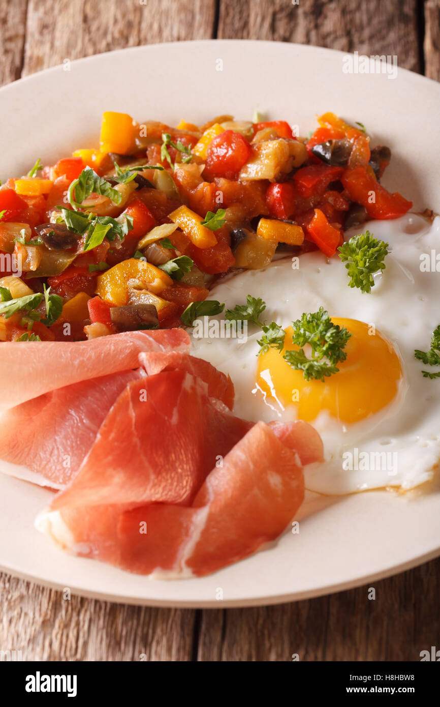 Spanish Food fried egg, ham and vegetables Pisto on the plate closeup
