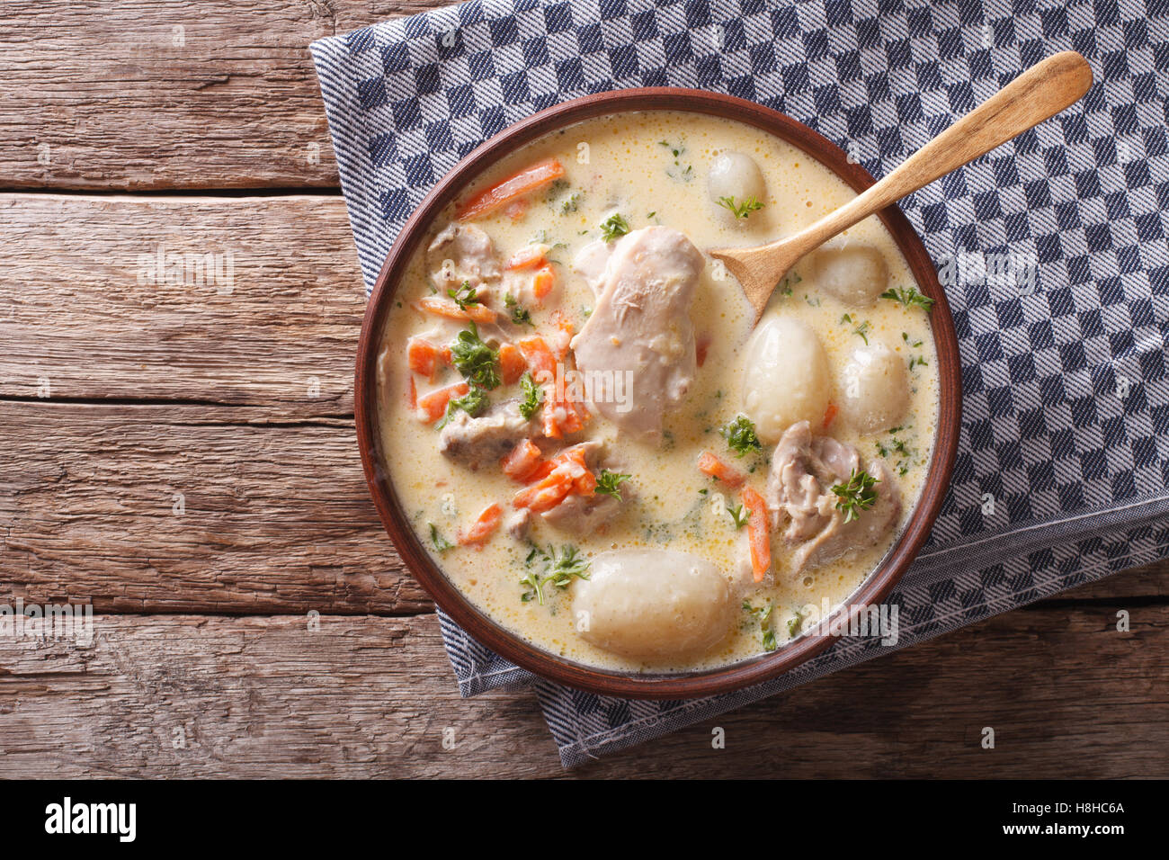 Creamy soup with chicken and vegetables close up in a bowl on the table. Horizontal view from above Stock Photo