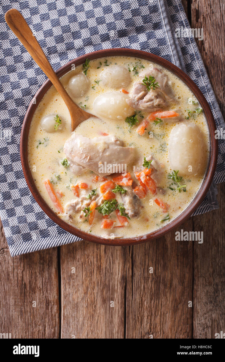 Creamy soup with chicken and vegetables close up in a bowl on the table. Vertical view from above Stock Photo