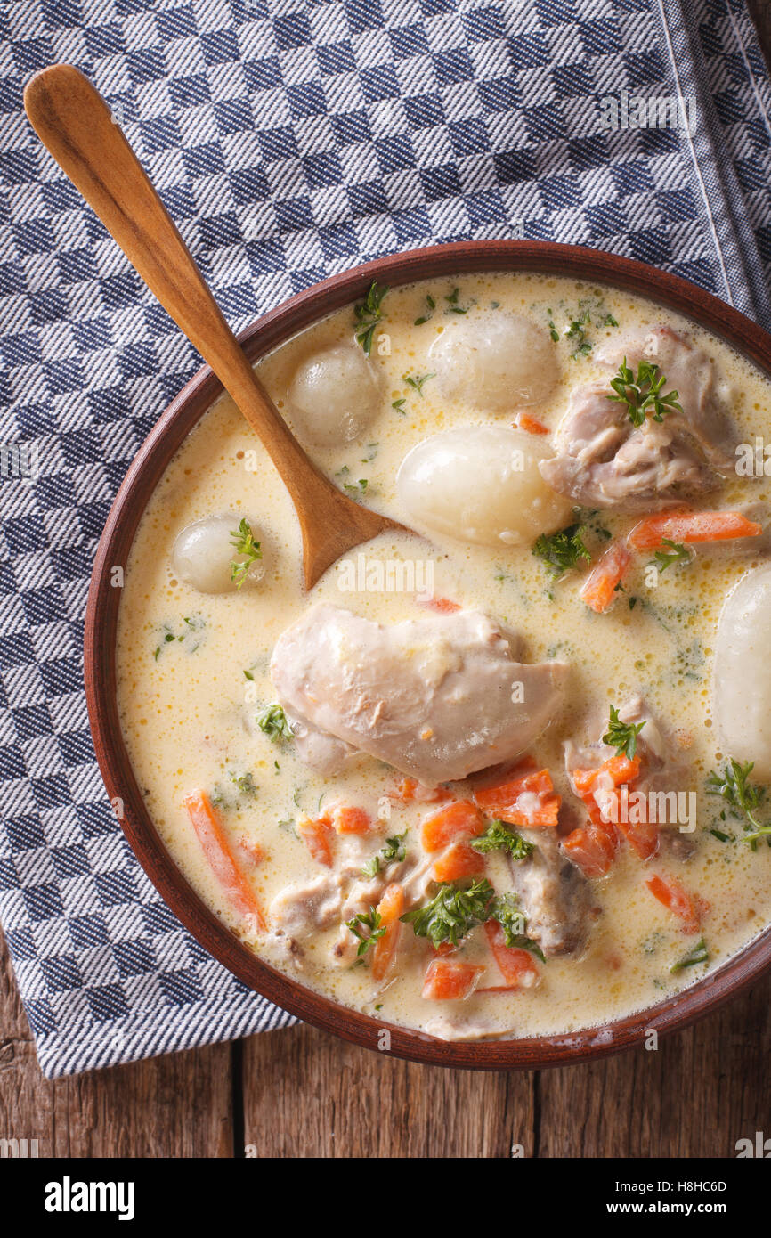 Belgian hot cream soup with chicken waterzooi close up in a bowl on the table. Vertical view from above Stock Photo