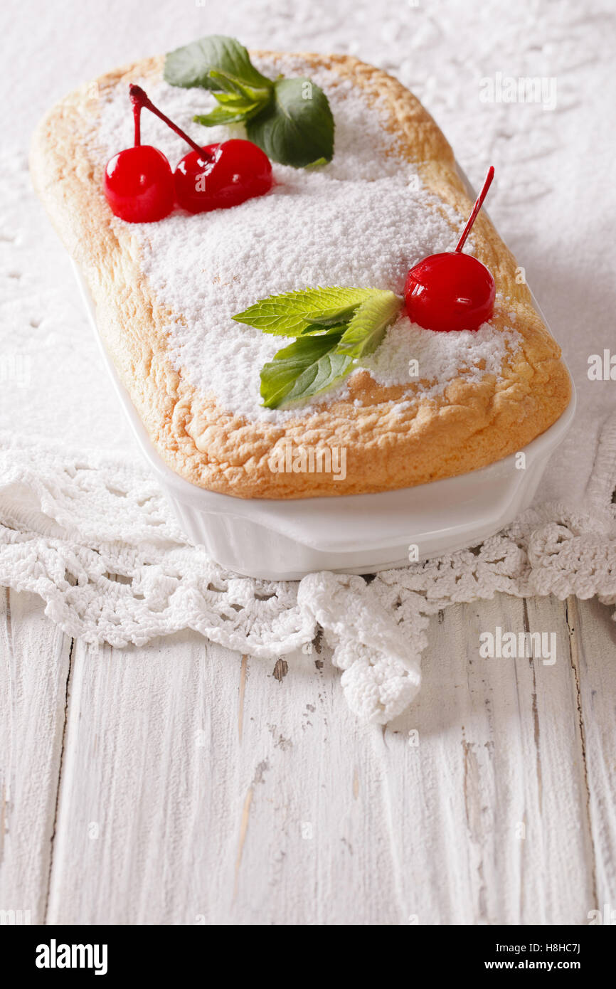 Delicate Austrian dessert Salzburger Nockerln with cherries and mint on a table. Vertical Stock Photo