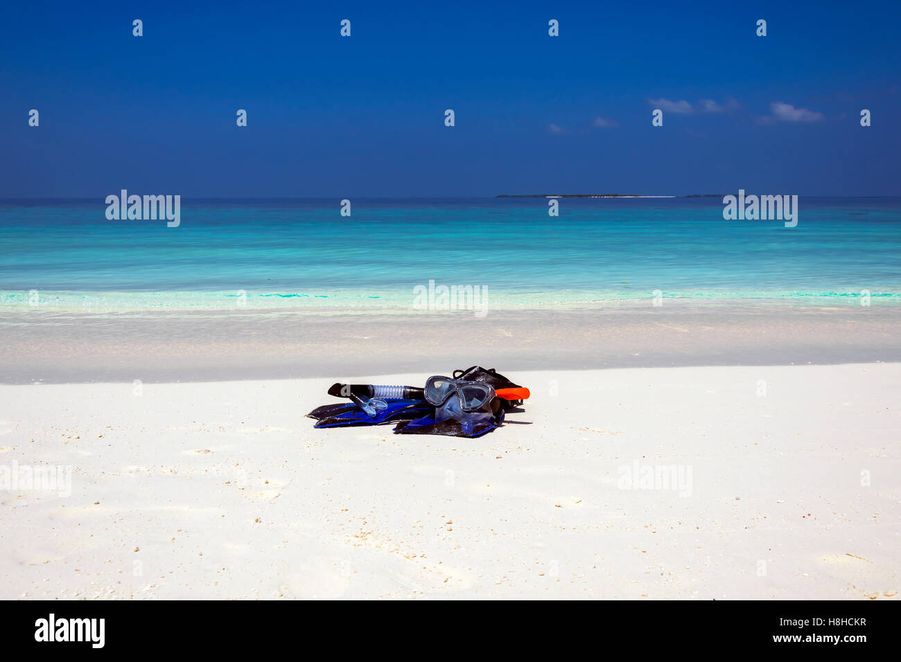 Snorkeling equipment lying on a white sand beach near the turquoise water, a heavenly scene taken on the amazing island Meedhupa Stock Photo