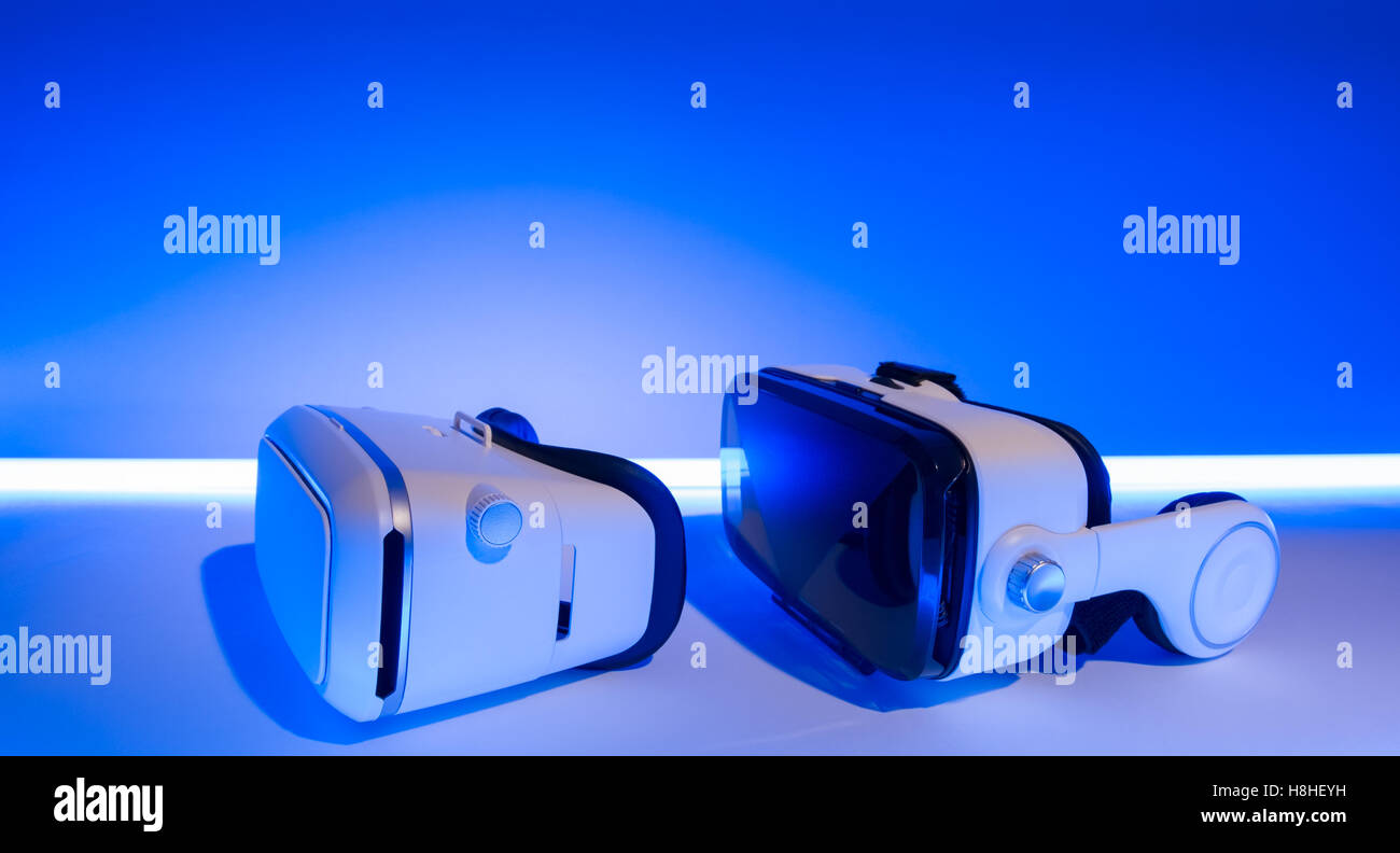 VR virtual reality glasses and 360 video vr virtual headset with earphones.  Blue background with neon light Stock Photo - Alamy