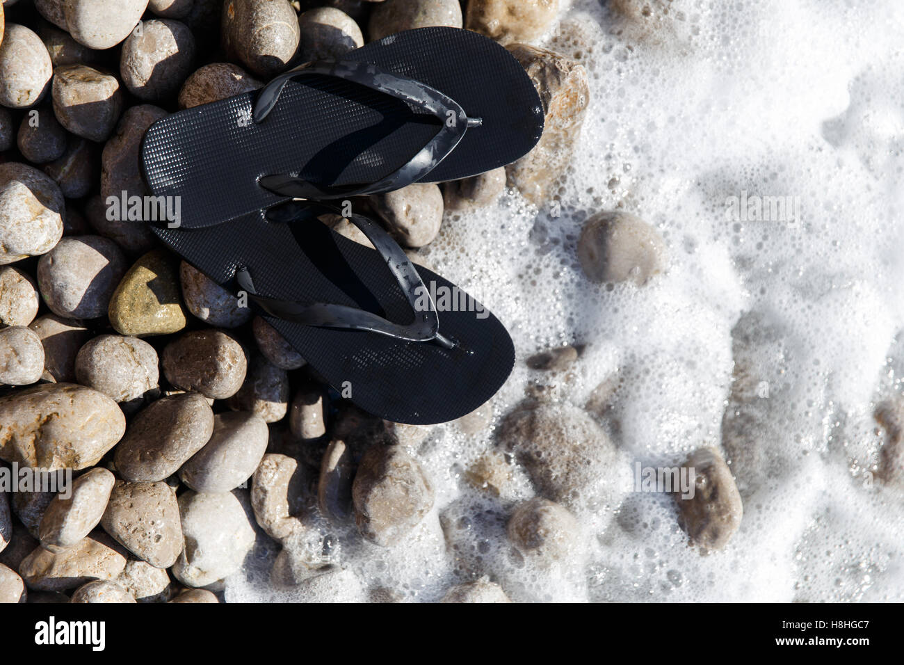 Shoes, pebbles on sea water Stock Photo Alamy