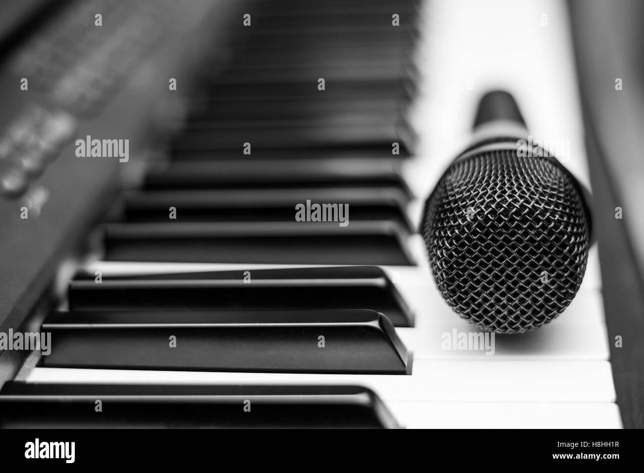 Close up microphone on piano keyboard in music studio Stock Photo