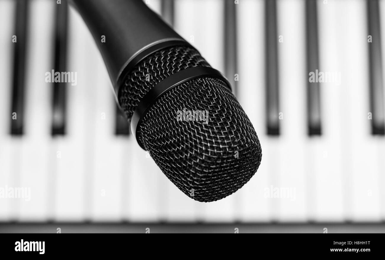 Close up microphone on piano keyboard in music studio Stock Photo