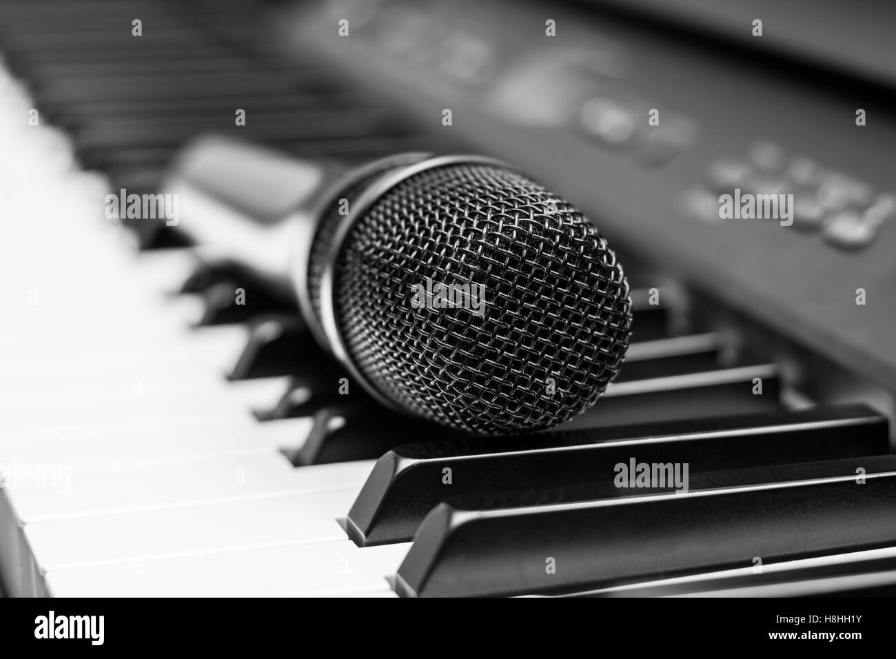 Close up microphone on piano keyboard in music studio Stock Photo