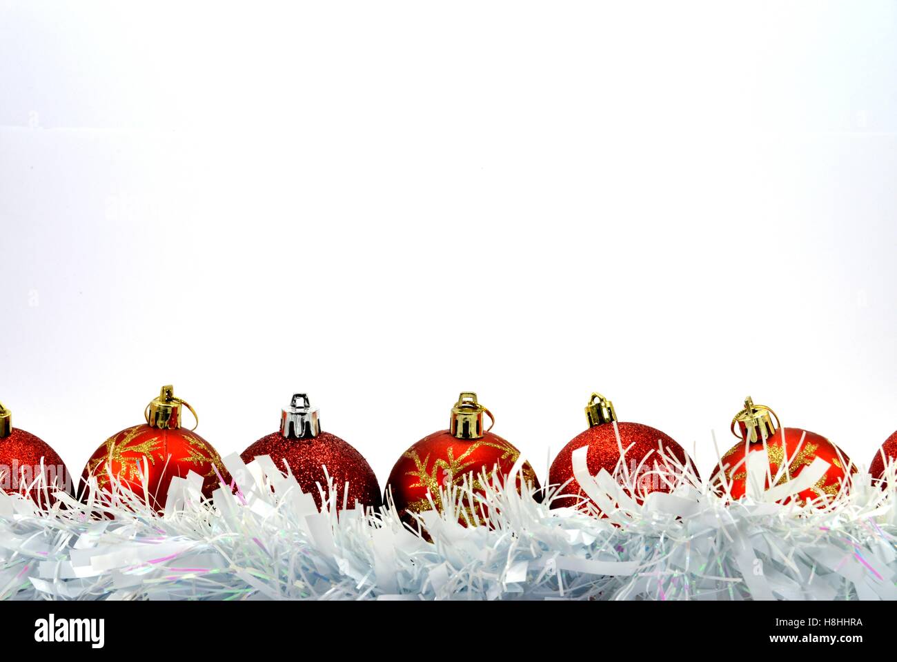 Several red and silver colored Christmas balls Placed in front of a white garland Stock Photo