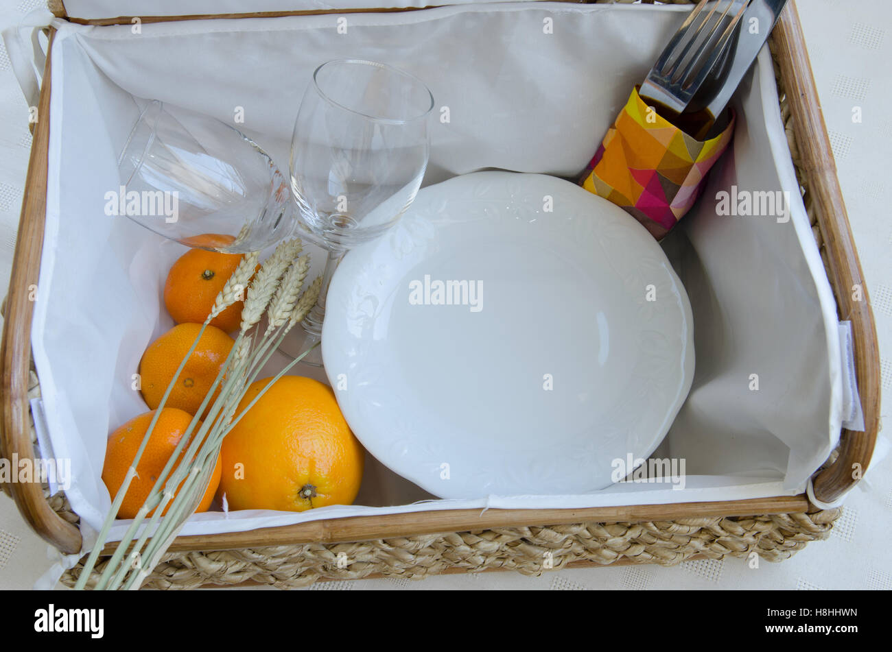 Picnic basket with wine glasses, fruit and food Stock Photo