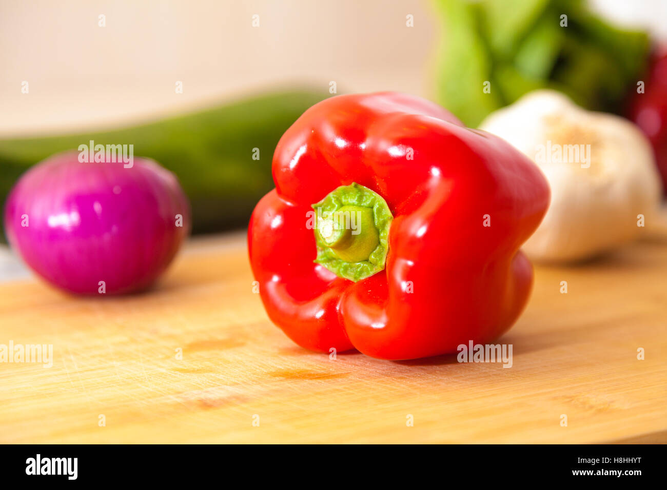 red paprika lies with other vegetables on a cutting board Stock Photo