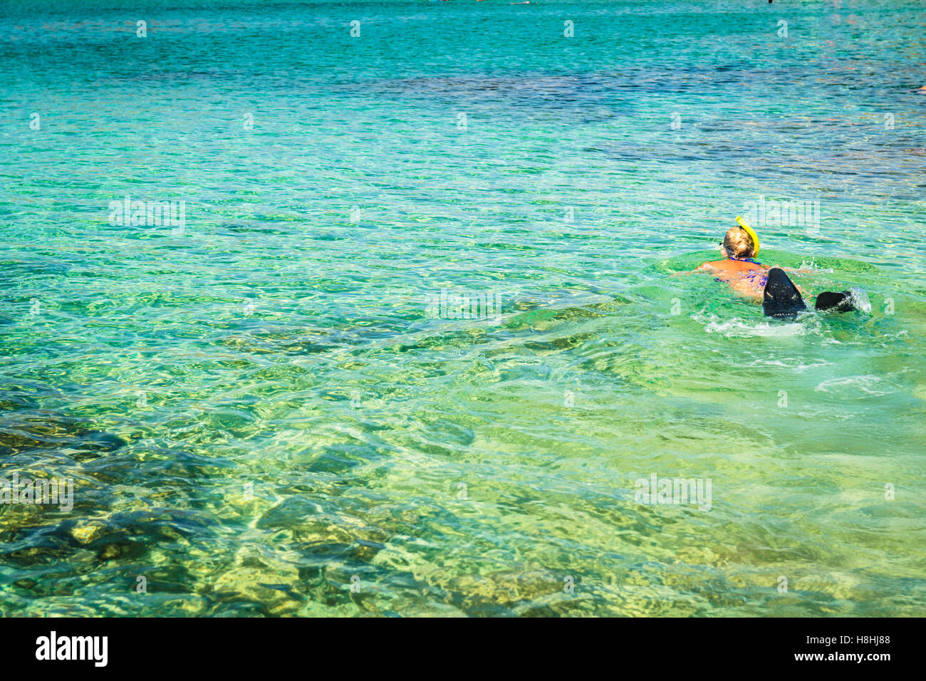 Blonde girl snorkelling in the crystal clear sea of Sardinia. Stock Photo