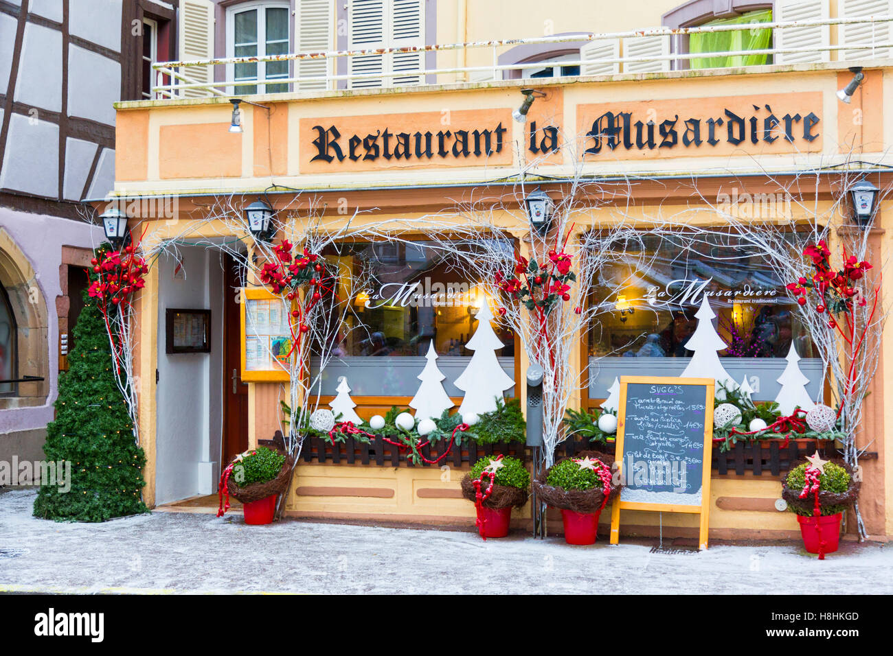 Christmas decorations on typical historic half-timbered restaurant, in the center of Colmar, wine route, Alsace, France Stock Photo
