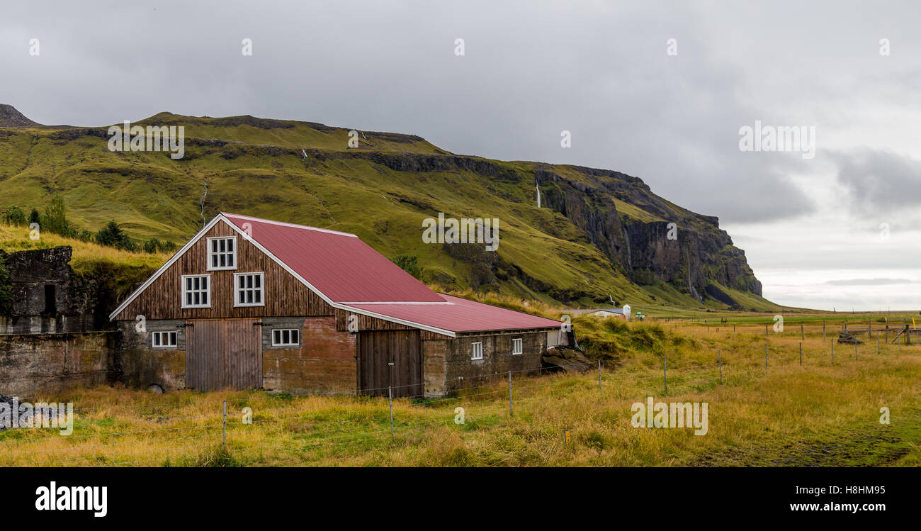 Farm house nestled into the mountainside in South Iceland Stock Photo
